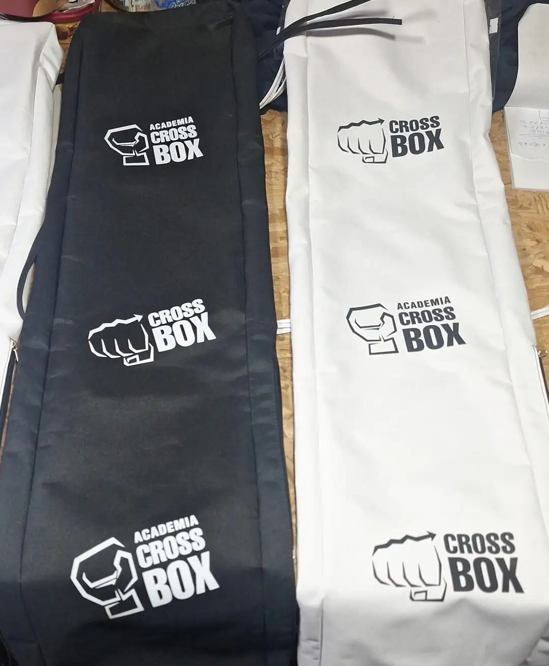 Bolsos deportivos blancos y negros con el logo de puño de Academia Cross Box estampado tres veces