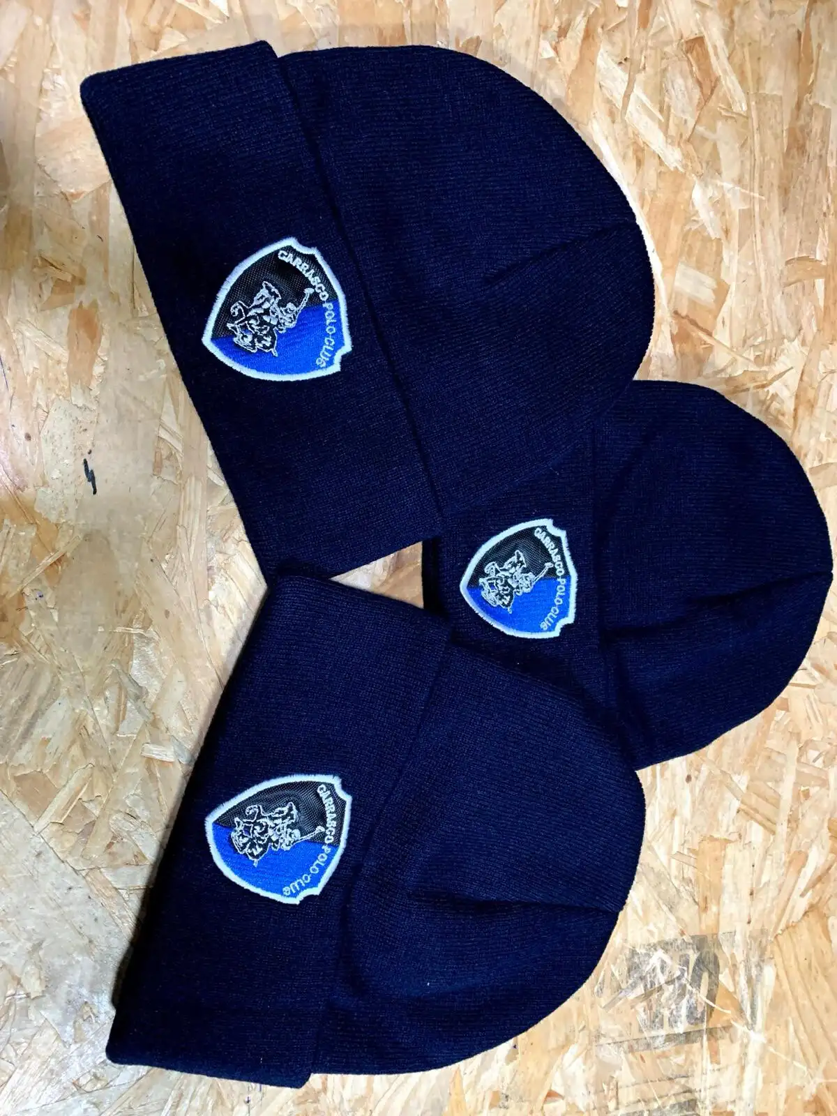 Tres gorros de lana azul marino bordados con el escudo del Carrasco Polo Club