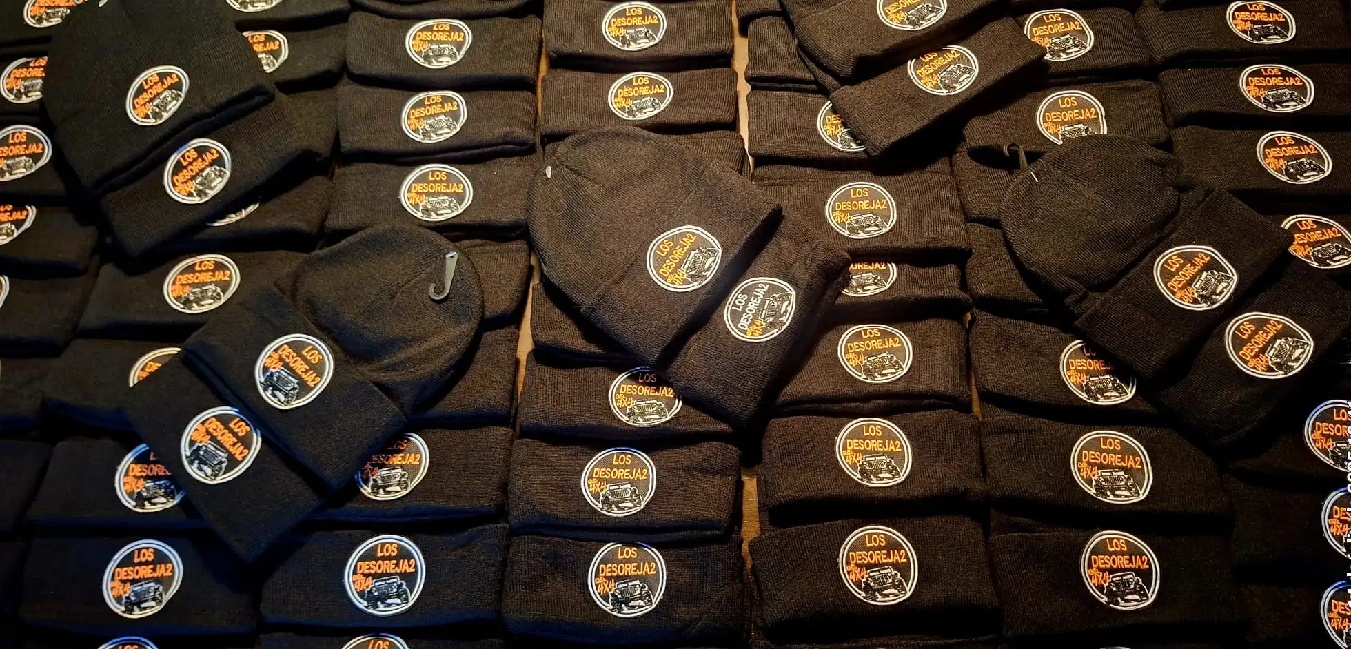 Decenas de gorros de lana negros bordados con el logo de Los Desoreja2 4x4