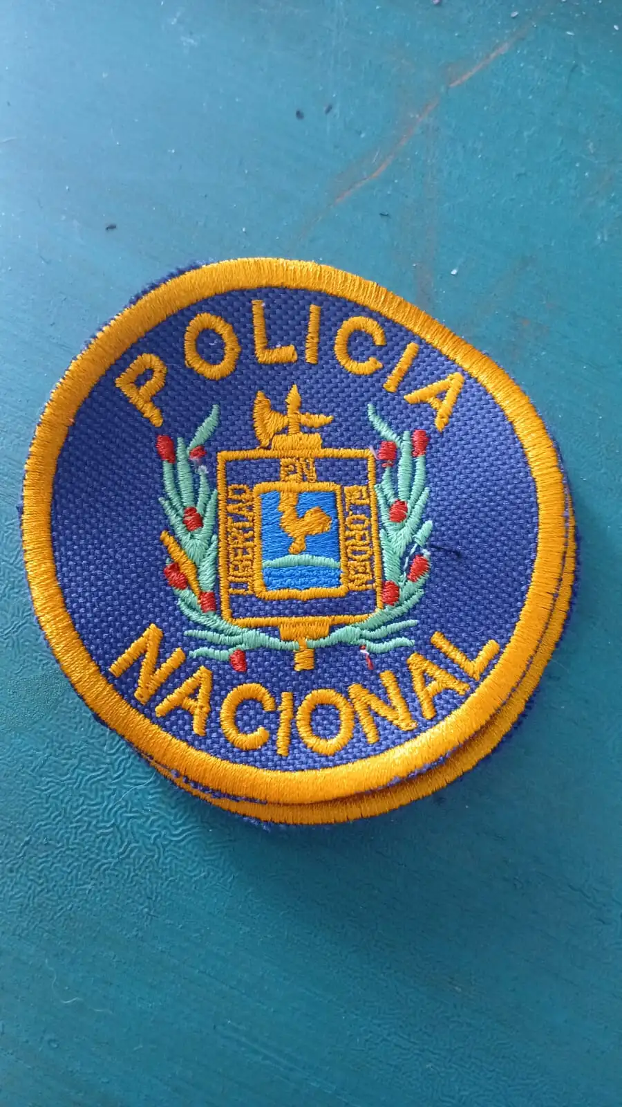 Parche bordado circular de la Policía Nacional del Uruguay, con el escudo nacional en hilo dorado y azul