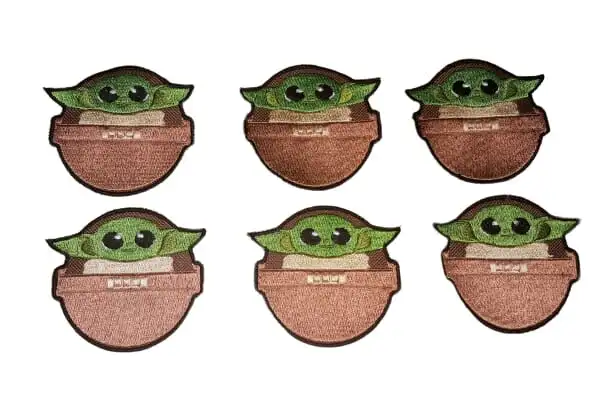 Seis parches bordados con un personaje verde de orejas grandes, recortados y terminados