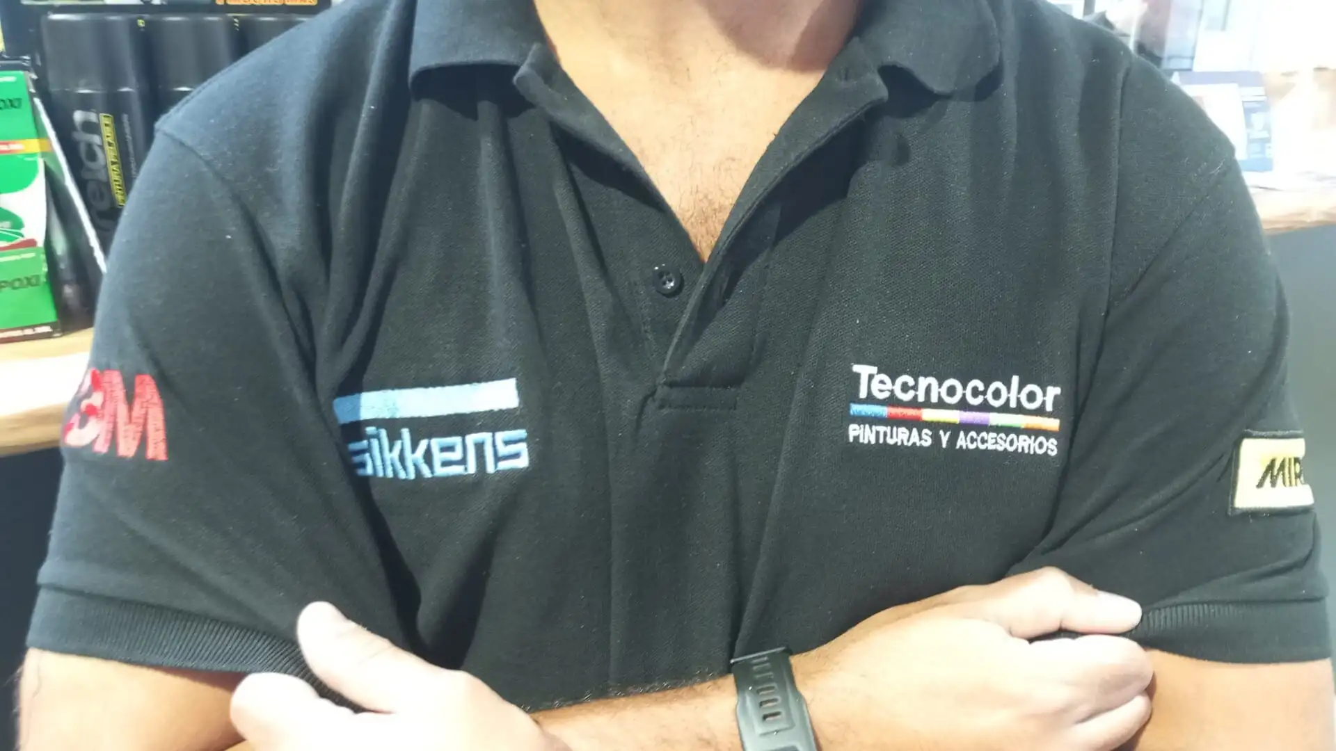 Polo negro con los logos bordados de Tecnocolor Pinturas, Sikkens y 3M en pecho y mangas